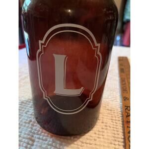 vintage decorative bottle with a handle and the initial L on the front